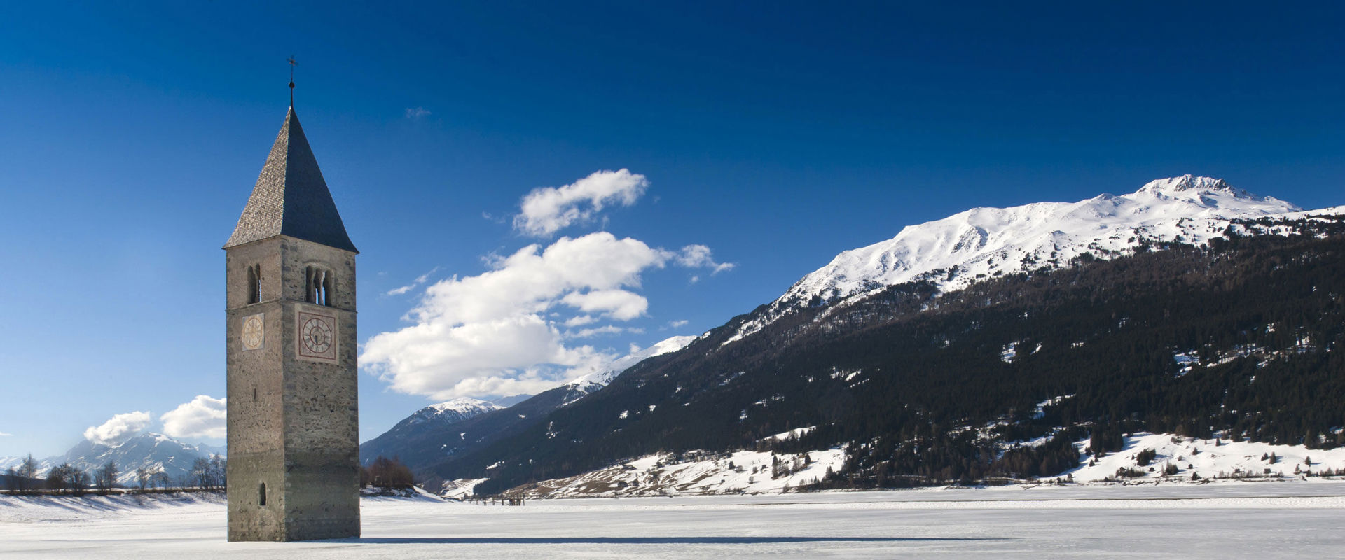 Winter at Lake Reschen Church tower rises out of the frozen Lake Reschen.