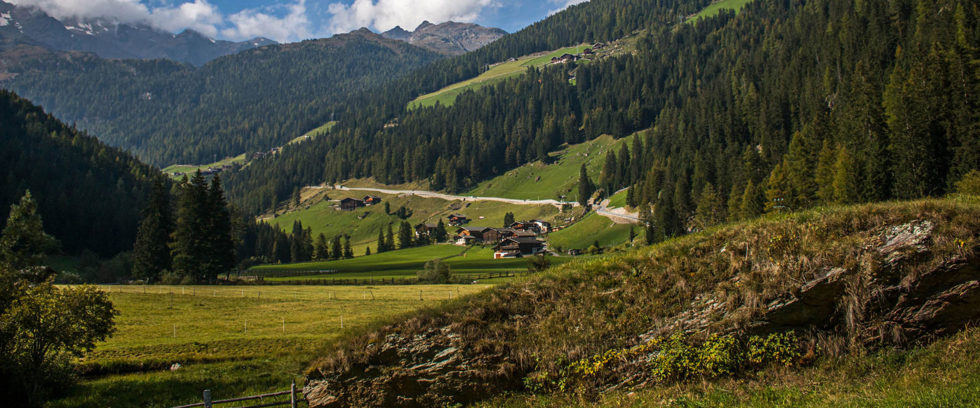 Ultental Mountain landscape with wooded slopes, road and scattered houses