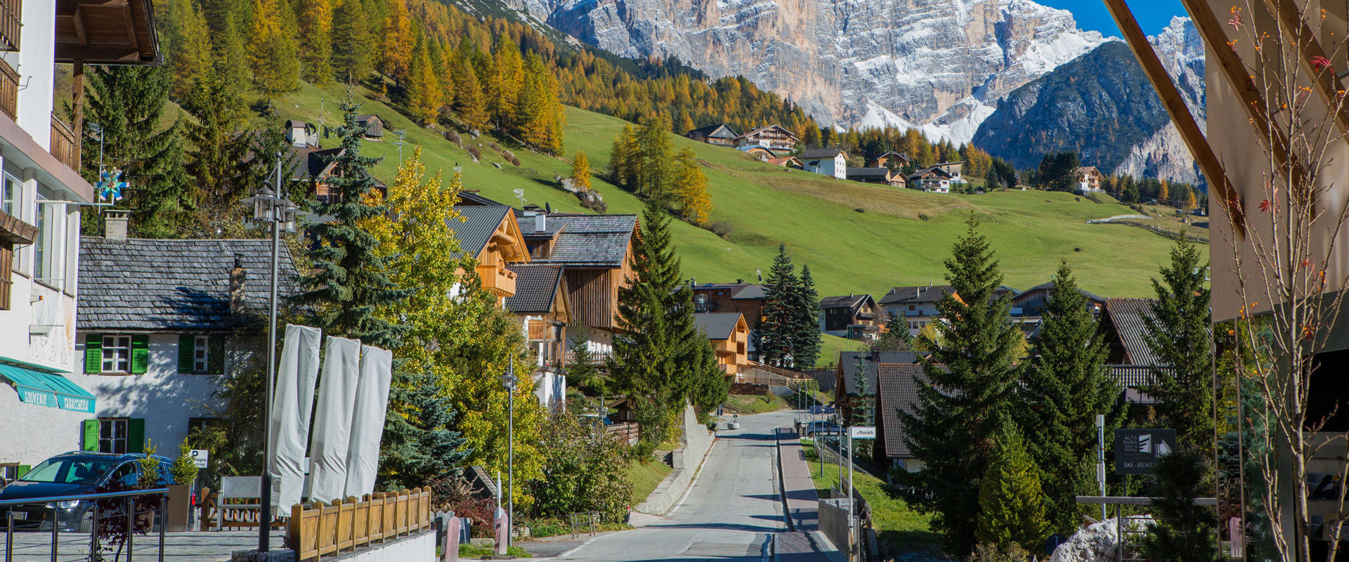 St. Kassian Street and houses in St. Kassian, cloudless sky and autumn colours