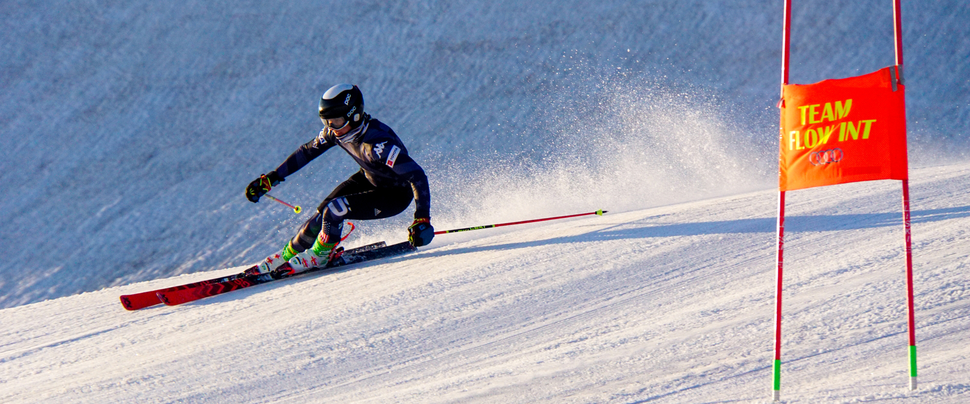 Stilfser Joch Skier with racing suit skiing along gates.