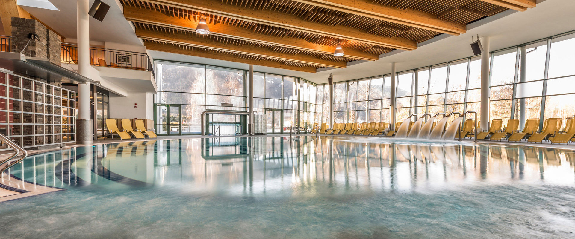 Indoor swimming pool with yellow loungers.