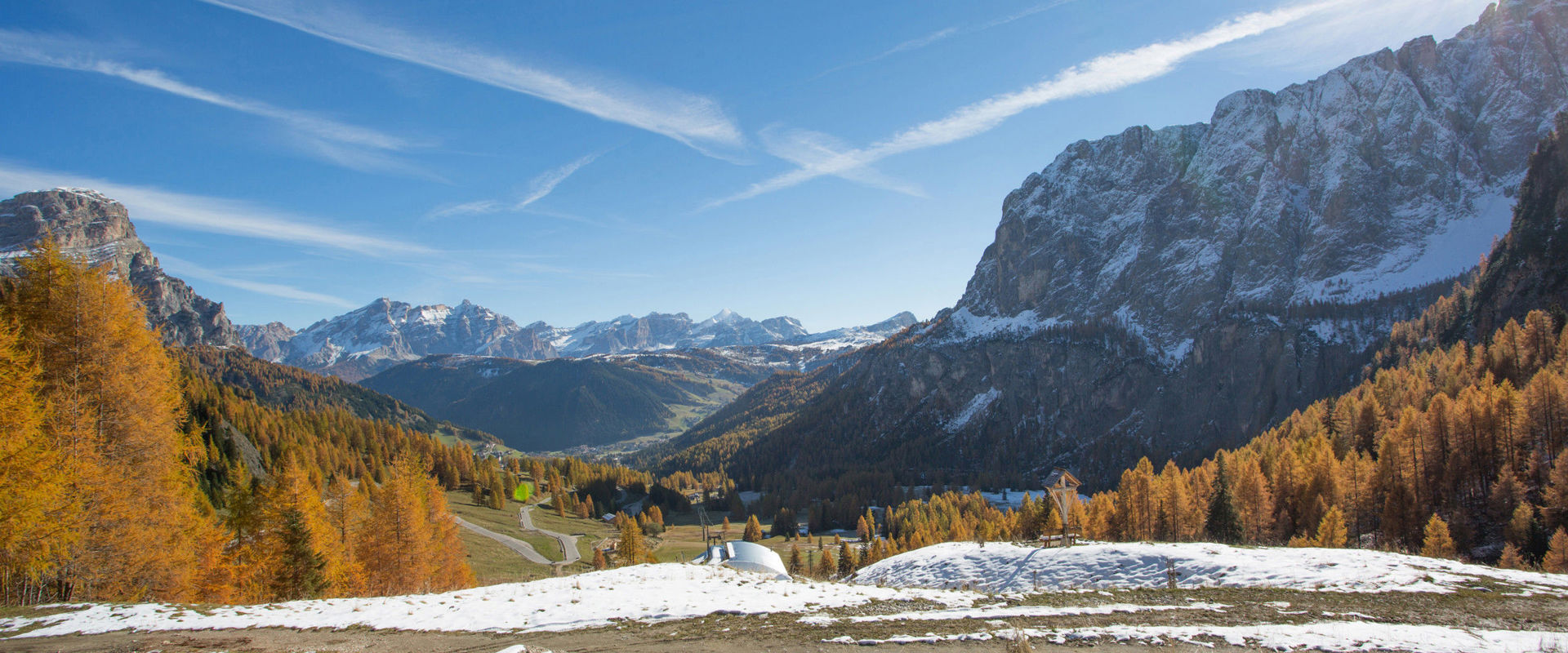 Snowy landscape with golden larches and Dolomites near Kolfuschg