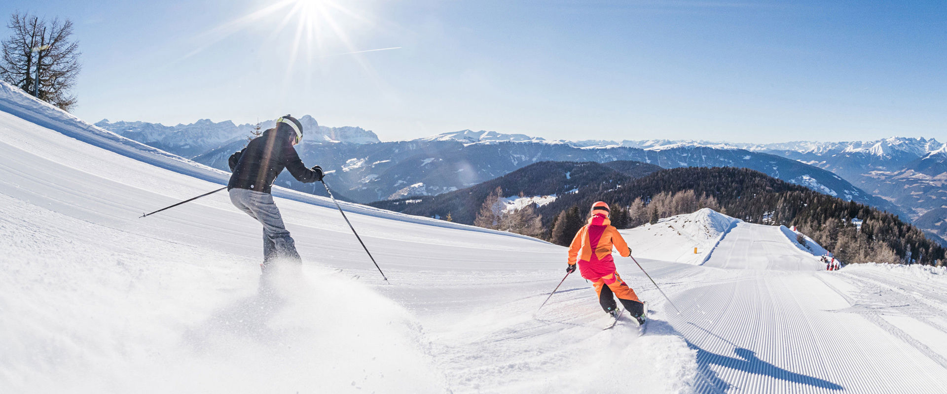 Dolomiti Superski 2 skiers ride down the freshly prepared slope.