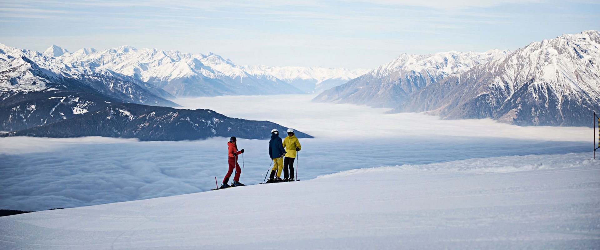 Ski area Meran 2000 3 skiers on the top of the mountain.