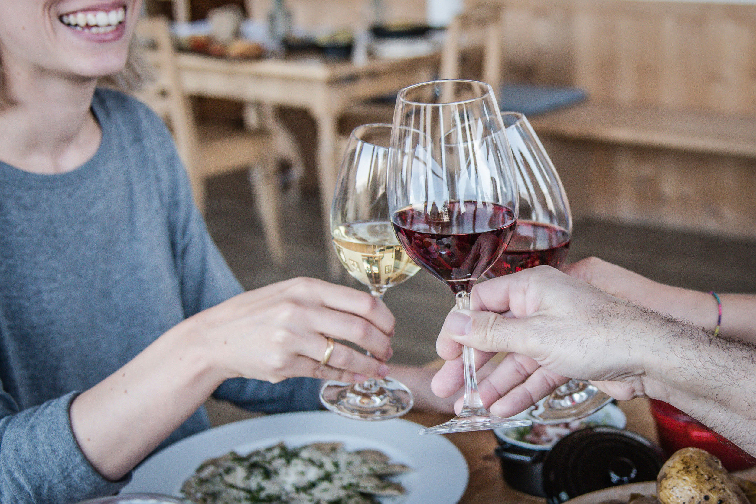 Friends toast together with a glass of wine.
