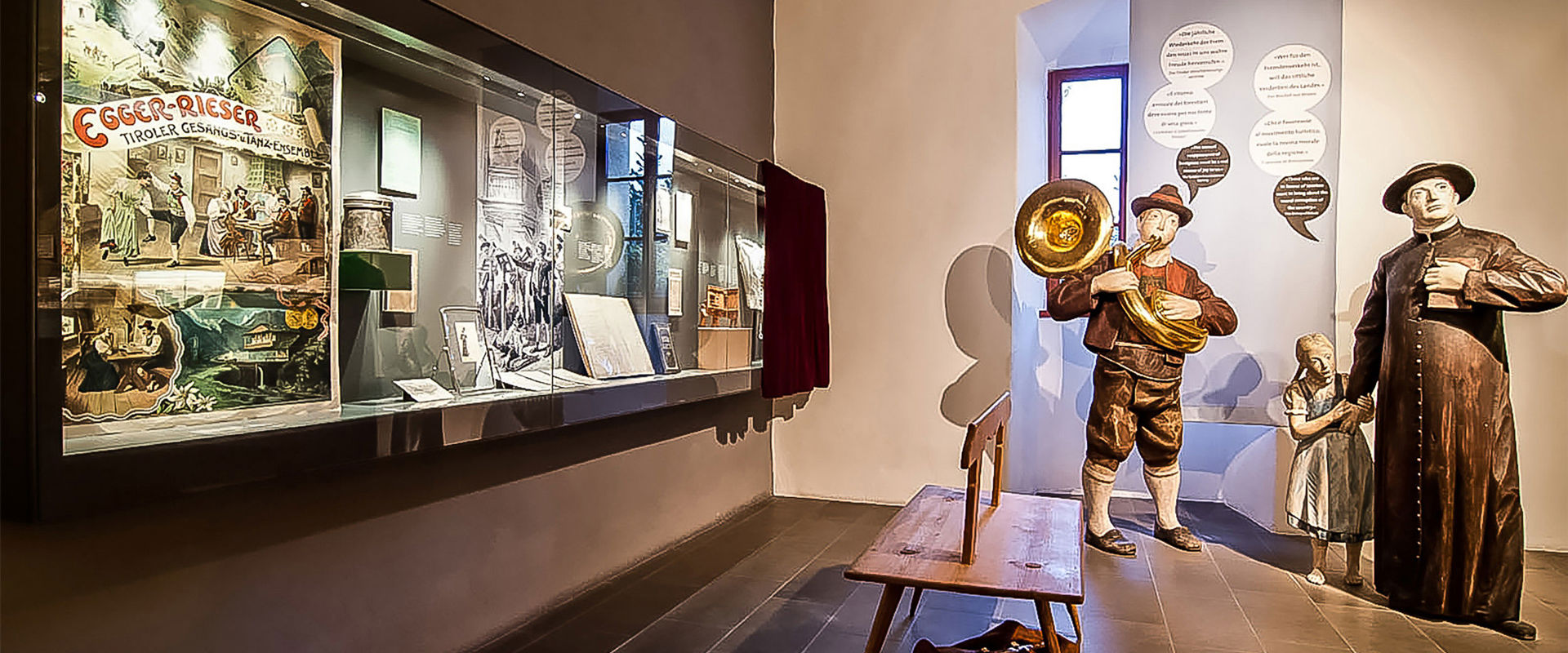 Touriseum Human-sized wooden figures and a showcase with various rural objects.