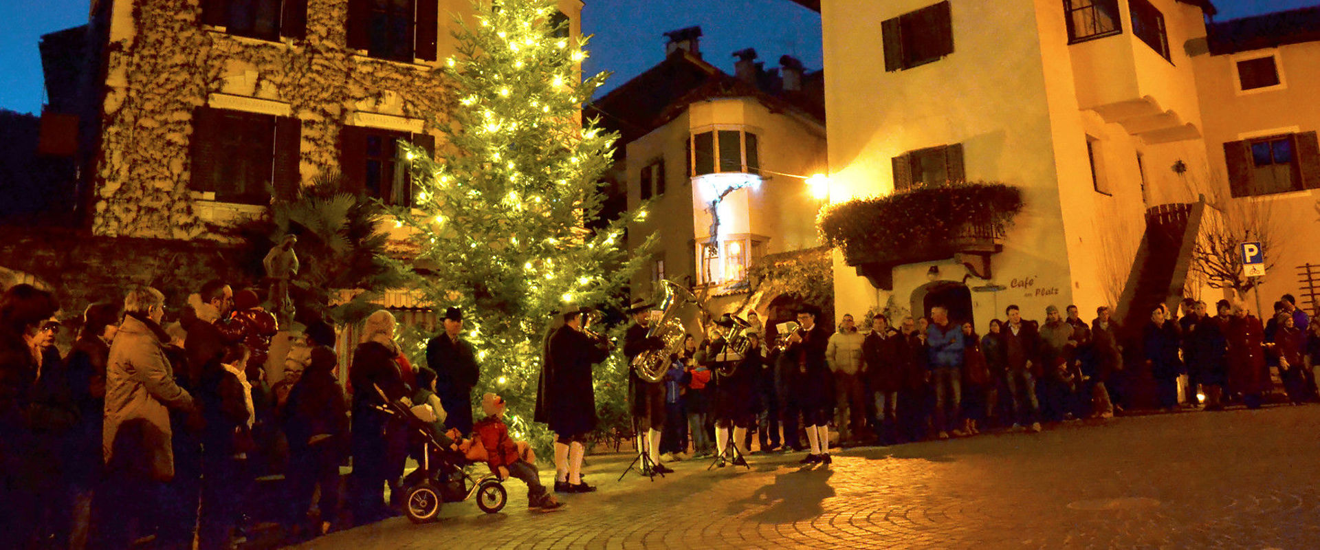 Girlan village square at Christmas time in winter Girlan village square with Christmas tree and music band.