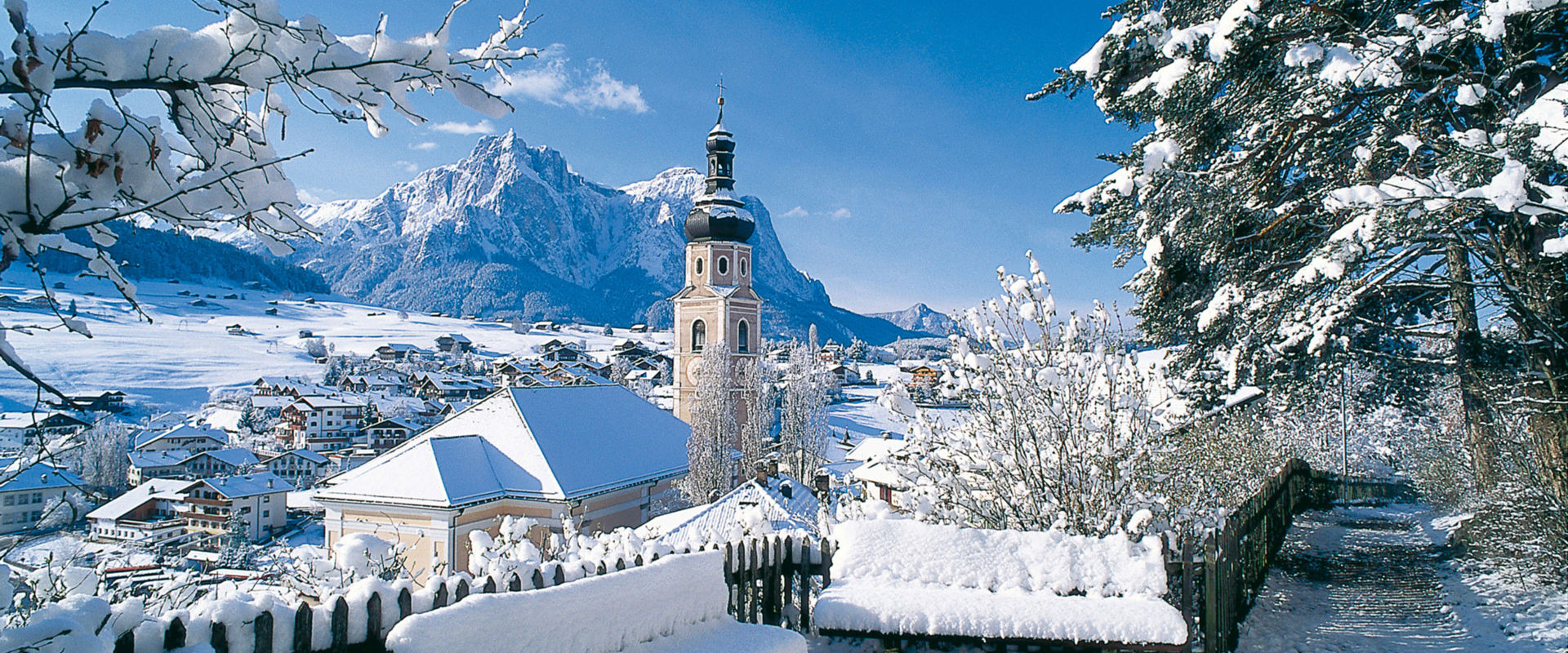 Winter landscape with snow-covered church of Castelrotto.
