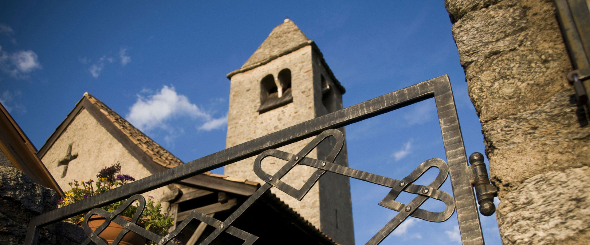 Proculus Church in Naturns near Meran View from below through the gate to the church and the steeple.