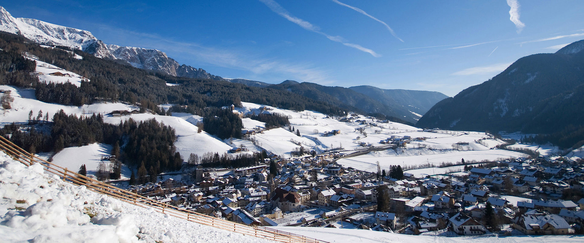Sarntal View of Sarnthein in winter under a bright blue sky
