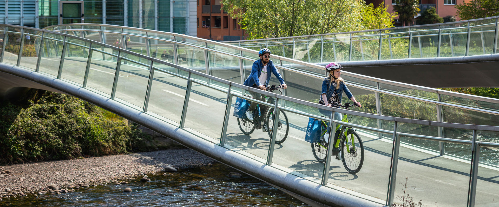 Cycle bridge at the Museion in Bozen. 2 cyclists on the cycle bridge in front of the Museion.