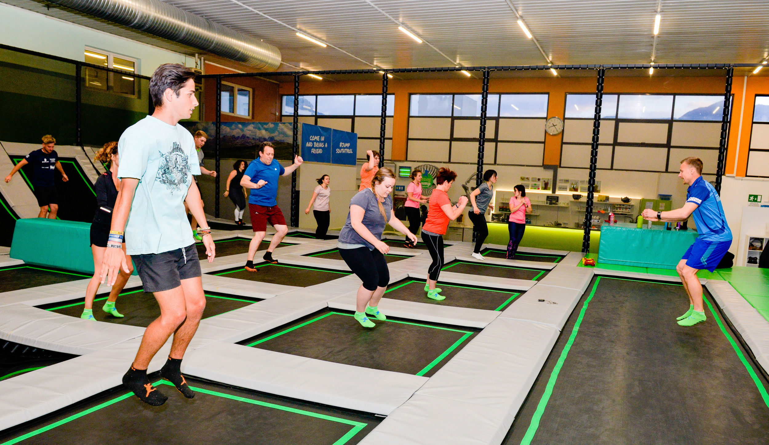 Group of adults jumping on a trampoline.
