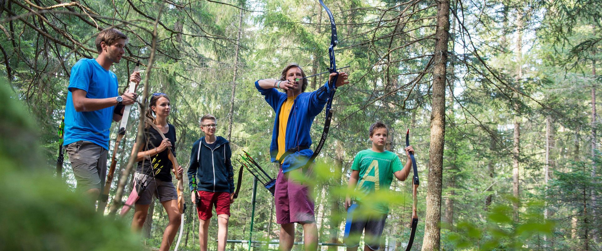 Archery trail in Olang. Group of youngsters trying their hand at archery.