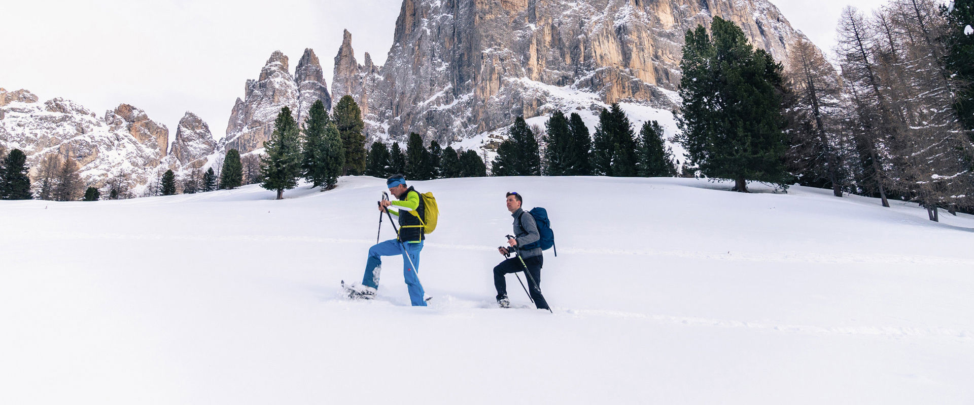 Latemar mountain range 2 Snowshoe hikers in front of the Latemar mountain range.
