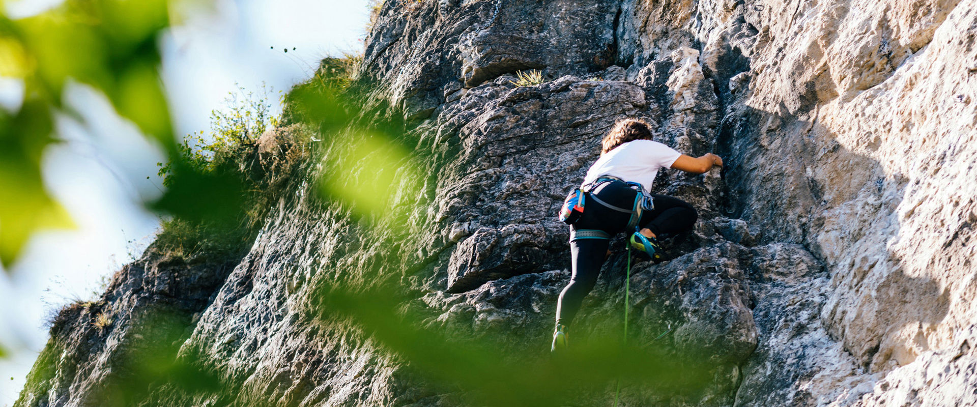 Outdoor Climbing in South Tyrol - Climbing area A woman climbing in the Marderwand climbing wall.