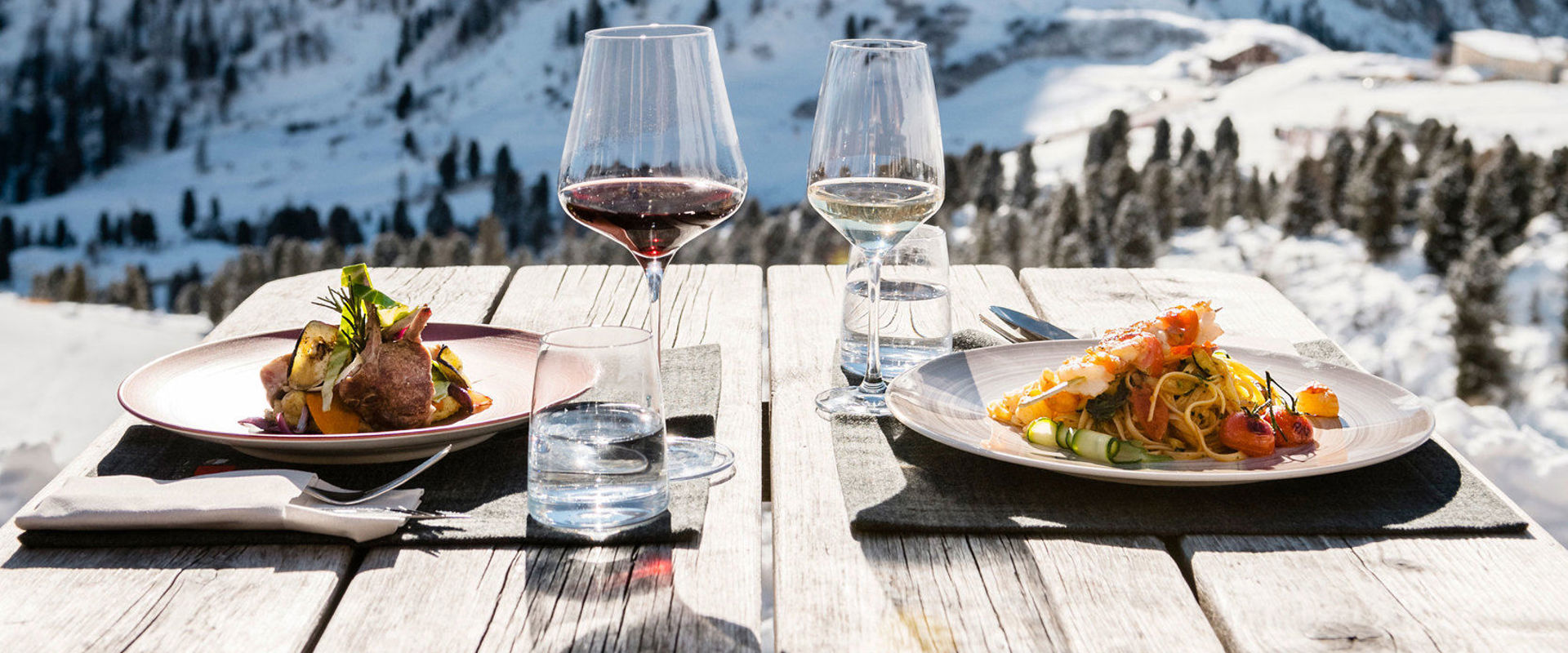Eating in a wintery, snowy landscape. Outdoor dining with a view of the Dolomites.