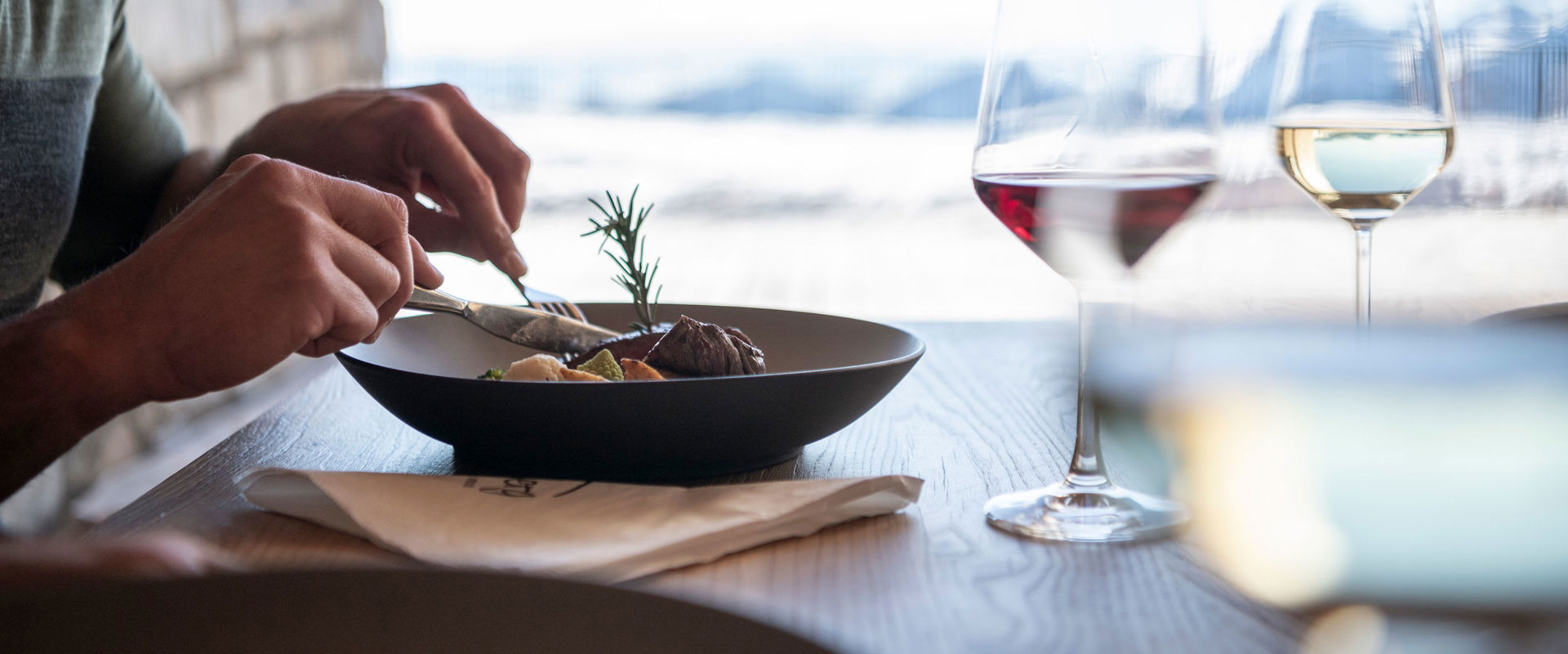 Restaurant with a view Man eating with a glass of wine.
