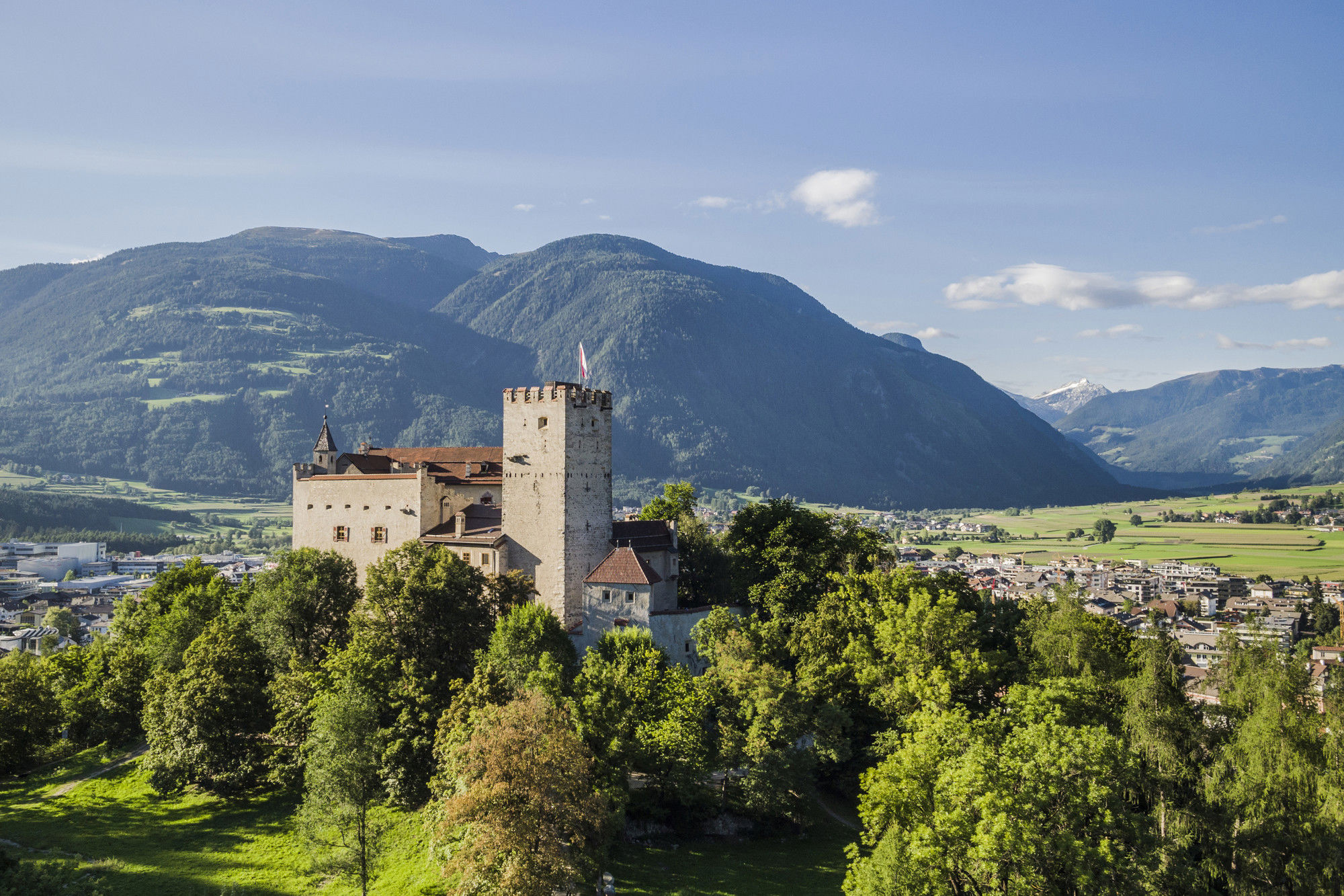 Castle perched on a hill in the middle of the city.