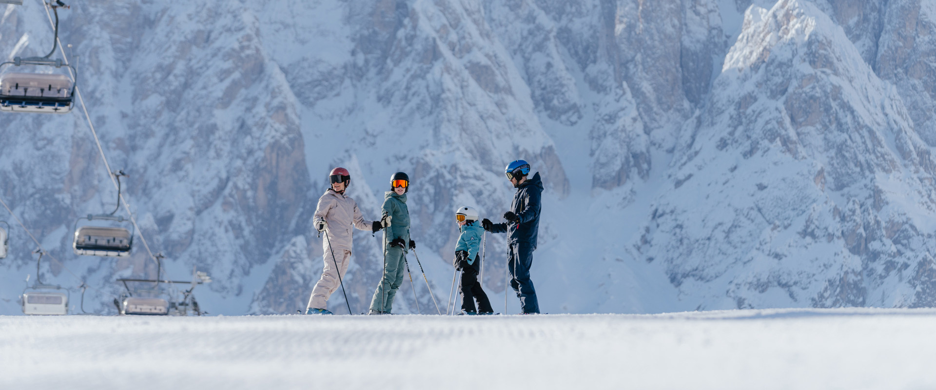 Skiing in the Dolomites Family of skiers standing on slope next to ski lift