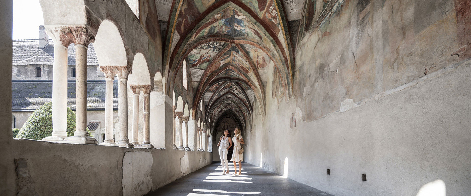 The cloister of Brixen Two women admire the frescoes of the cloister.