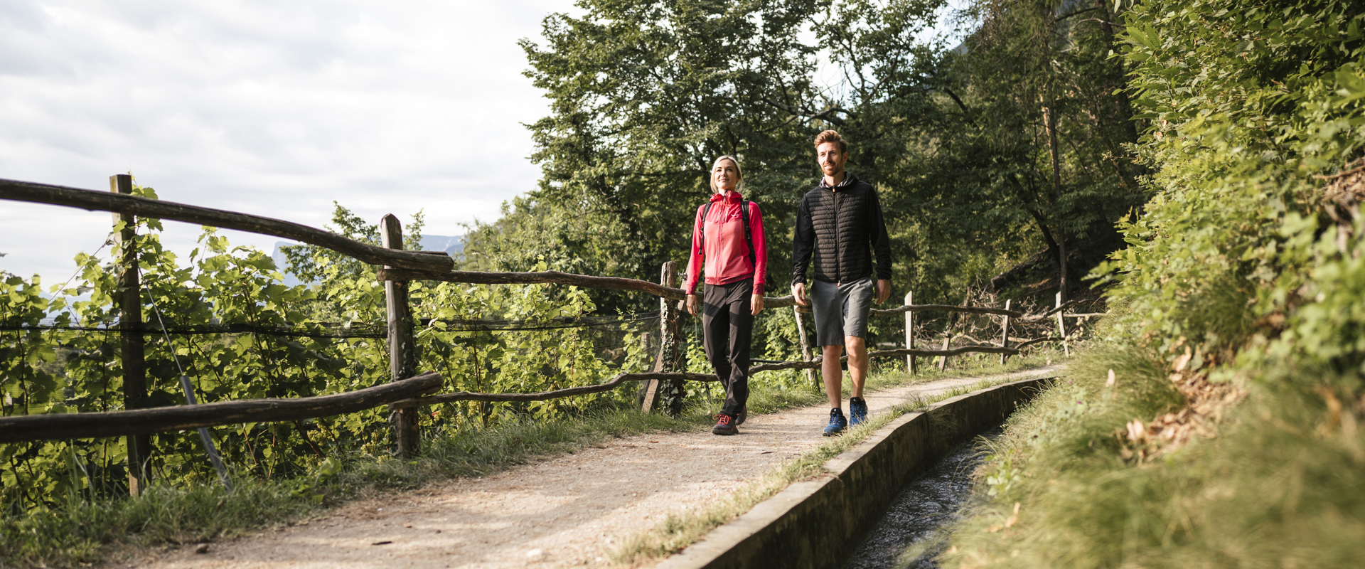 Hikers on walking path along an old irrigation channel in Marling