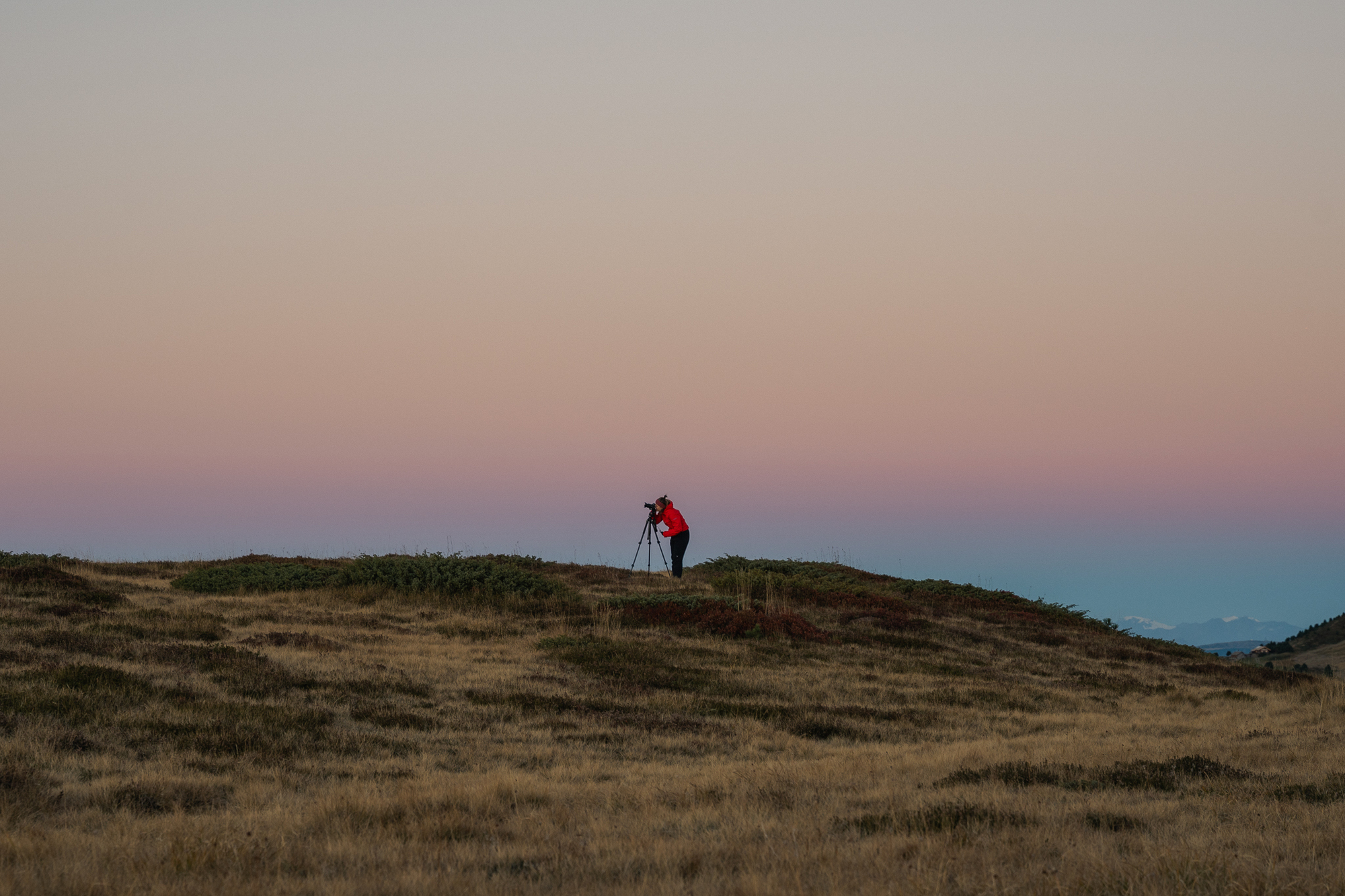 Photographer at twilight and sunset on a mountain meadow