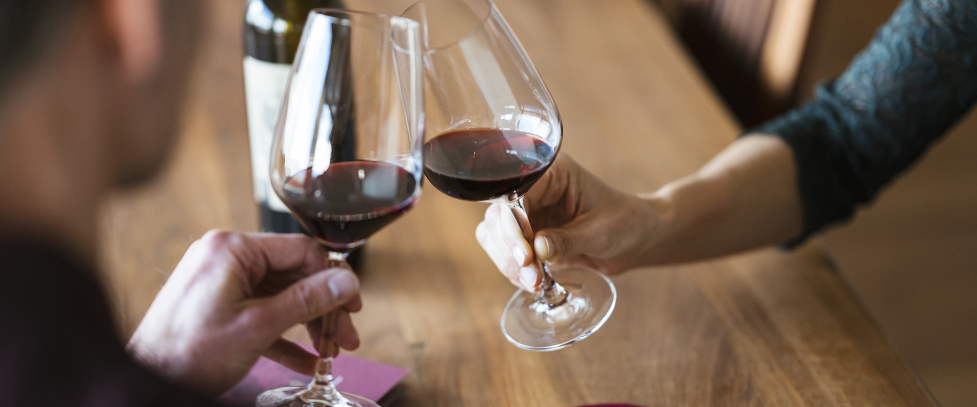 Wine & pleasures in Marling Man and woman toasting with glasses of red wine