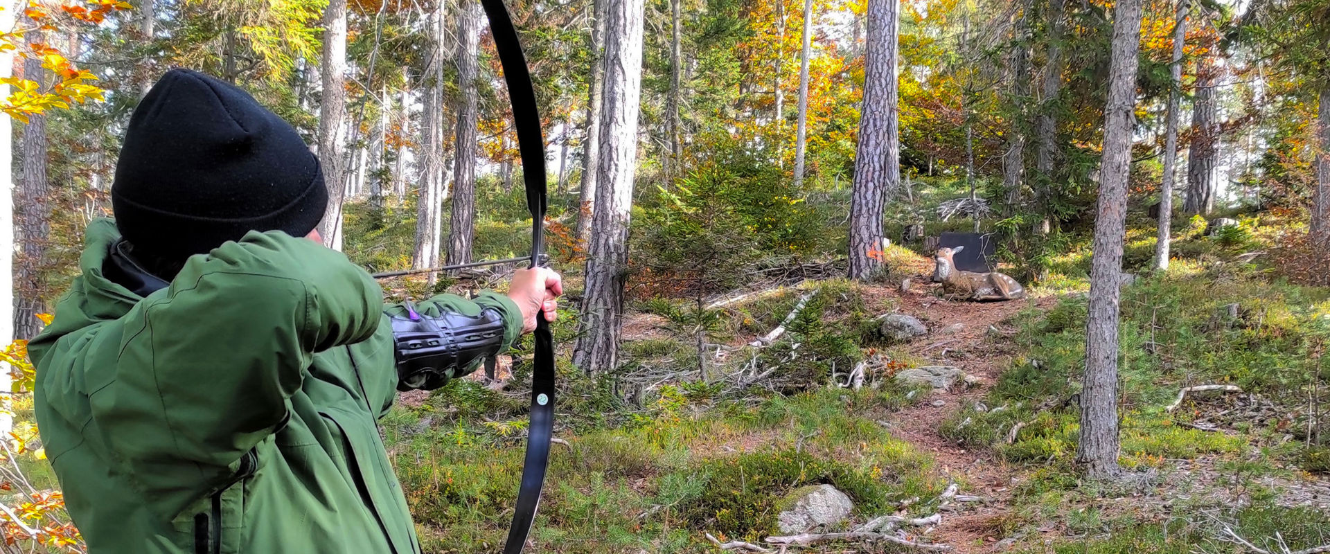 3D RiArco archery course in the forest near Unterrinn A man takes aim to hit a wooden target in the Ritten archery course.