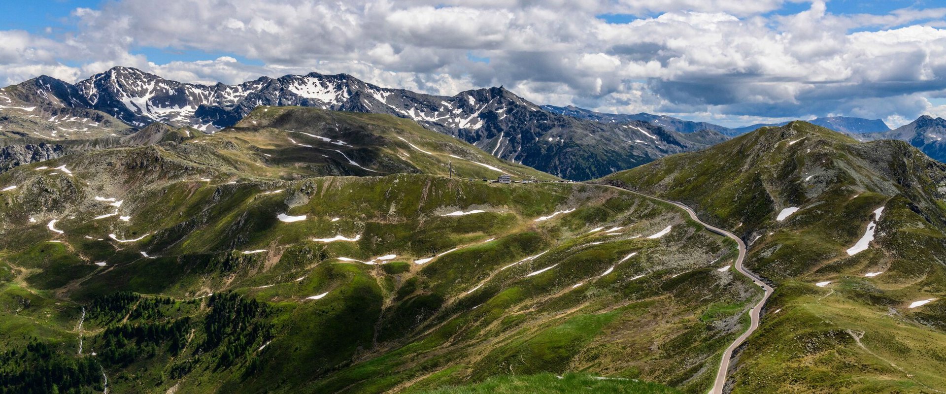 View of the Penser Joch, the pass road and the mountain landscape from the hiking trail