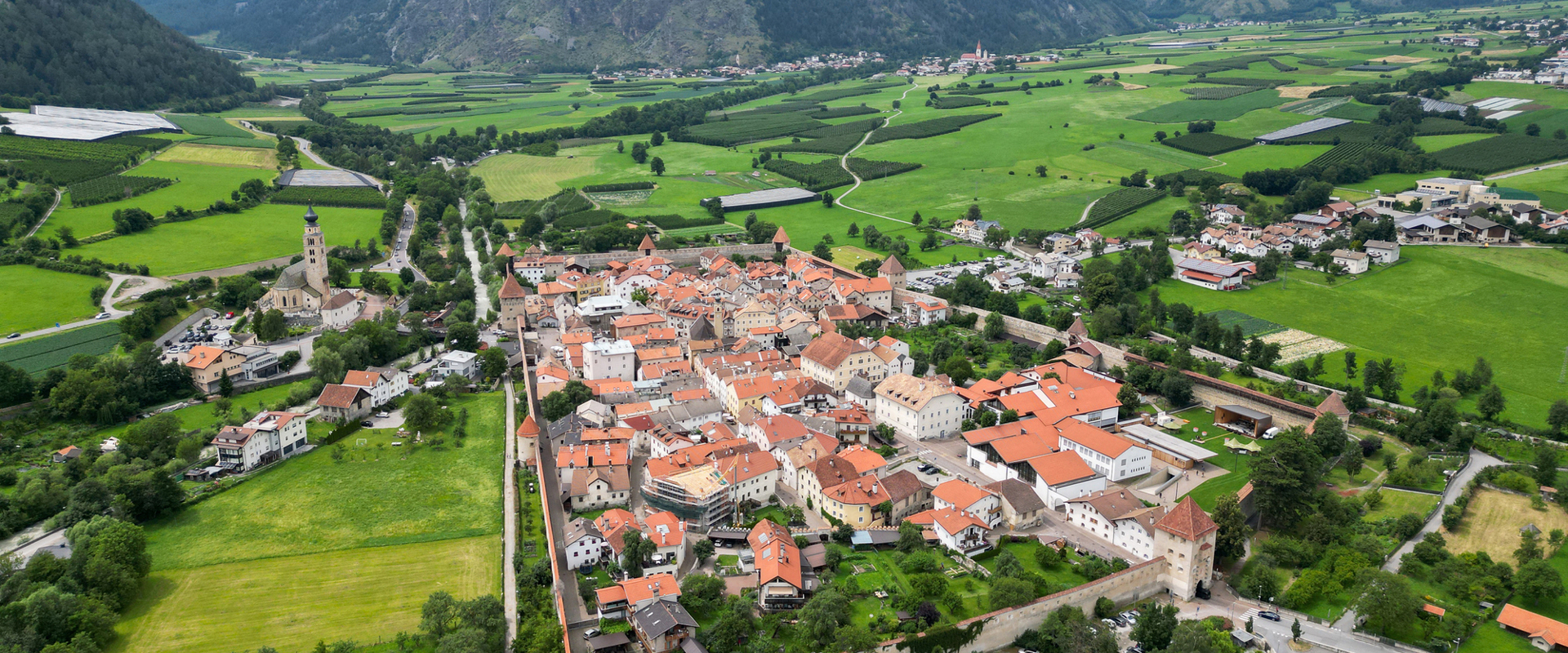 View from above of a small town surrounded by an old city wall with towers